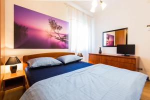 a bedroom with a bed and a tv on the wall at Apartment Anna in Zadar
