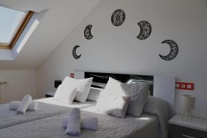 um quarto com duas camas com adesivos lunares na parede em Ático CREDENCIAL em Sarria