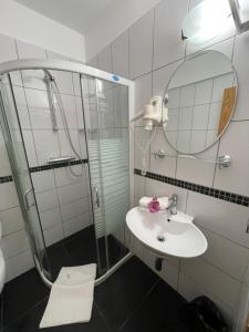 a bathroom with a shower and a sink and a mirror at Ametist Casa Leului in Mamaia Sat/Năvodari