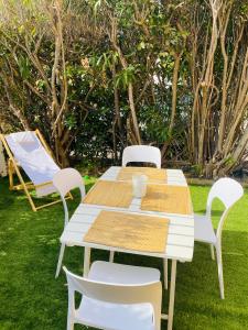 a white table and chairs in the grass at Les Tamaris in Saint-Cyr-sur-Mer