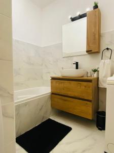 a bathroom with a sink and a tub at Les Tamaris in Saint-Cyr-sur-Mer