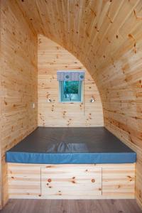 a bed in a wooden cabin with a window at Luxury Rural Ayrshire Glamping Pod in Dalmellington
