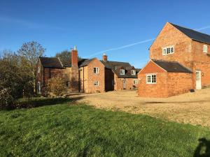 a group of brick buildings in a field at Cosy getaway near Rutland Water in Oakham