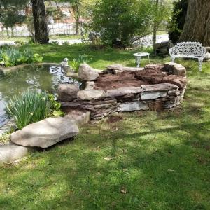 a pond in a yard with a bench and a table at The Emig Mansion in York