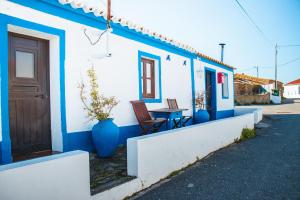 een blauw-wit huis met een tafel en een deur bij Paraíso dos Avós in Farelos de Baixo