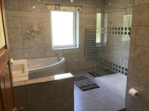 a bathroom with a tub and a sink and a shower at Heulwen Guest House in Dolgellau +34 photos