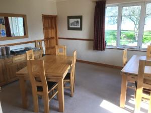 a dining room with a wooden table and chairs at Heulwen Guest House in Dolgellau