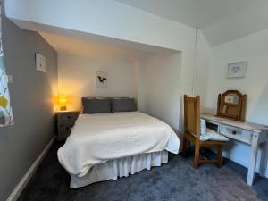 a bedroom with a bed and a desk and a chair at The Ship Inn in Gloucester