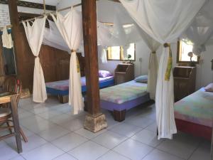 a bedroom with two beds and a canopy bed at VH Surf Camp in Pacitan