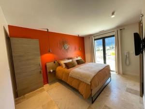 ein Schlafzimmer mit einer orangefarbenen Wand und einem Bett in der Unterkunft Domaine Mas Terra in Saint-Paul-de-Fenouillet