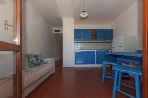 a kitchen with blue cabinets and a couch in a room at Elba Island Resort Pool & Tennis in Nisporto