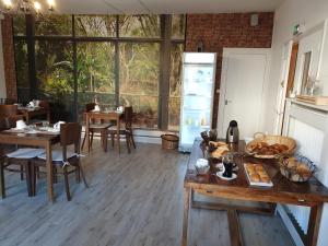 un comedor con mesas y sillas y una gran ventana en Hôtel Saint Cyr, en La Ferté-Saint-Cyr