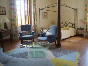 een woonkamer met een bed en een tafel en stoelen bij Chateau de Juvigny in Juvigny-sur-Marne