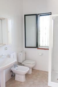 a white bathroom with a toilet and a sink at Rosmarino Park in SantʼAgata di Militello