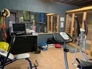 a room with a gym with a treadmill and a desk at Dom’s Garden in Livarot