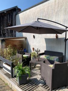 une terrasse avec un parasol, des tables et des chaises dans l'établissement Dom’s Garden, à Livarot