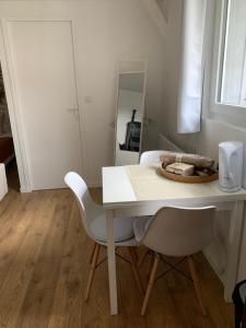- une table et des chaises blanches dans une pièce avec un miroir dans l'établissement Dom’s Garden, à Livarot