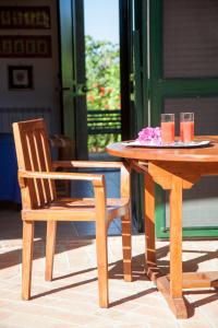 a wooden table and a chair sitting next to a table at Rosmarino Park in SantʼAgata di Militello