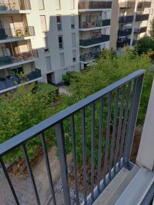 - un balcon dans un immeuble d'appartements avec un banc dans l'établissement Le Gaïa - Joli appartement au calme 10min du centre de Lyon, à Villeurbanne