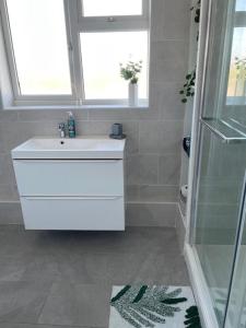 a bathroom with a white sink and a window at 3 bedroom modern flat, sleeps 8, Mablethorpe, Linc in Mablethorpe