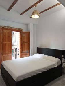 a bedroom with a large bed and a ceiling fan at Apartamentos con encanto en pleno casco antiguo RON VALENCIAYOLE in Valencia