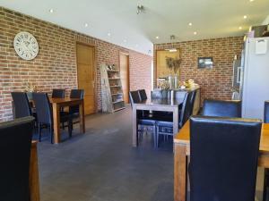 a restaurant with tables and chairs and a brick wall at Jaegershoes in Belfeld