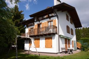 a large white building with a balcony and a table at Santi’s Apartment in Folgaria
