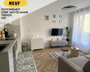 uma sala de estar com um sofá e uma televisão em Les Rives Saint Symphorien, appartements meublés em Longeville-lès-Metz