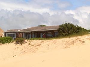a house sitting on top of a sand hill at The Unexpected at Cannon Rocks in Cannon Rocks +17 photos