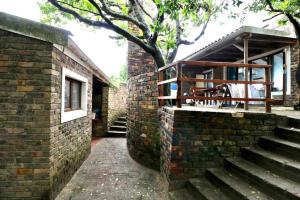 a brick building with a porch and stairs in front at The Unexpected at Cannon Rocks in Cannon Rocks