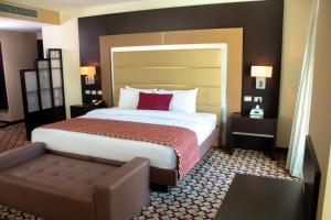 a hotel room with a large bed and a couch at Waldorf Hotel in Caracas