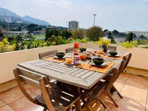 einen Holztisch mit Essen auf dem Balkon in der Unterkunft Marseille 8ème - T3, 4 couchages, terrasse - proche plage in Marseille