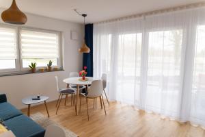 un soggiorno con un tavolo e un divano blu di FeWo Aurora am Bodensee a Friedrichshafen