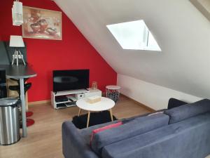 uma sala de estar com um sofá azul e uma televisão em Les Iris, Malo les bains, 350 m de la plage em Dunkerque