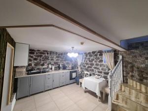a kitchen with stone walls and a table and a staircase at Vila Maresal in Buşteni