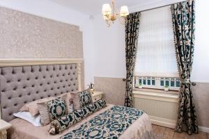 Un dormitorio con una cama grande y una ventana en Vila Maresal, en Buşteni