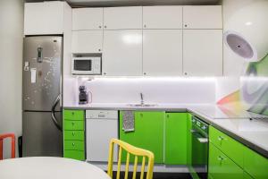 a kitchen with green cabinets and a refrigerator at Central Studio Apartment in Tampere