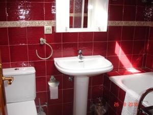 a red tiled bathroom with a sink and a toilet at La Ería de Colombres in Colombres +23 photos