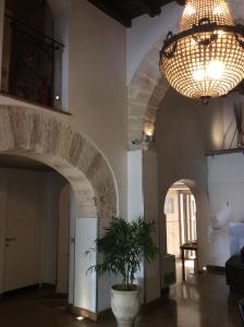 Habitación con maceta y lámpara de araña. en Ucciardhome Hotel en Palermo