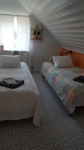 1 dormitorio con 2 camas y ventana en B&B Parksäter en Håcksvik