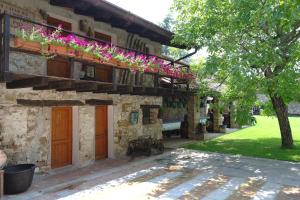 un edificio con flores a un lado. en Agriturismo il Vagabondo, en Buttrio