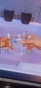 uma pessoa que segura dois copos de vinho numa mesa em מלון כרמל/מגדל C em Netanya