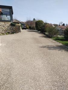 an empty driveway with a car parked in a house at Chaleureux à la campagne in Saint-Germain-Laprade