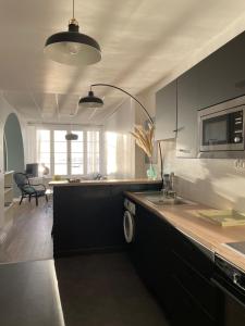 una cucina con lavandino e bancone con forno a microonde di Douceur Marine a Cancale