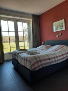 een slaapkamer met een bed met rode muren en ramen bij Jaegershoes in Belfeld