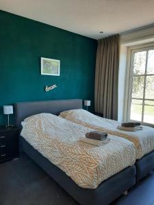 a bedroom with a bed and a green wall at Jaegershoes in Belfeld