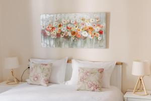 uma cama com duas almofadas e um quadro na parede em Best House, Psila Alonia Square Luxury, Patra em Patra