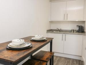 - une cuisine avec une table en bois avec des assiettes et des bols dans l'établissement Chalet 3, à Ganton