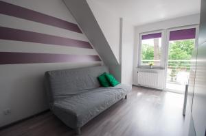 a room with a couch with a striped wall at Noclegi Pobierowo NATALIA - przy morzu in Pobierowo