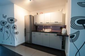 a kitchen with white cabinets and a refrigerator at Noclegi Pobierowo NATALIA - przy morzu in Pobierowo